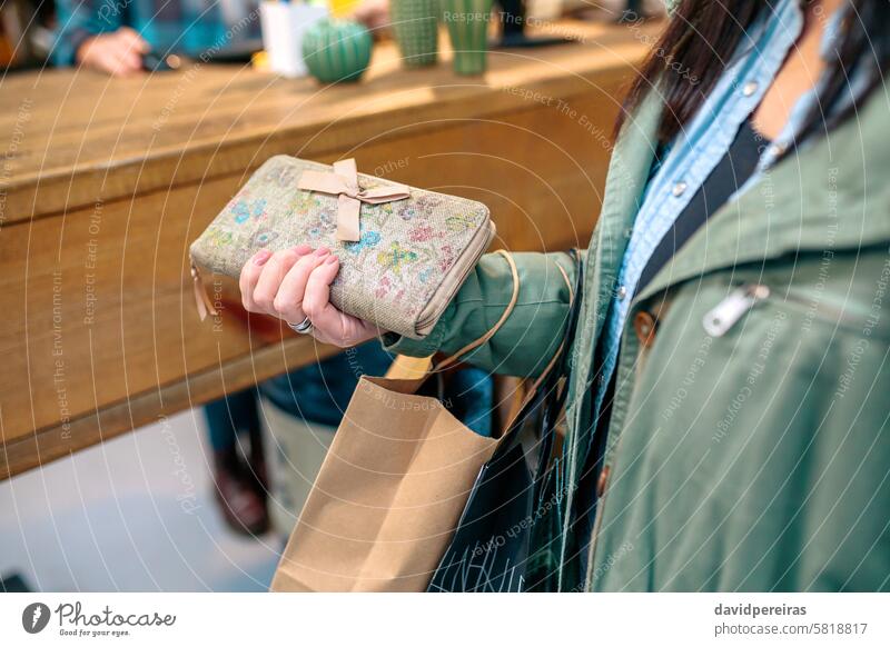 Unrecognizable woman client holding wallet with bow and ecological shopping paper bags on store unrecognizable customer hand recycle counter local female ready