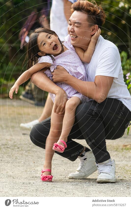 Joyful Asian Father Playing with Daughter on European Trip asian family vacation europe father daughter play laughter travel joy parent child happiness bonding
