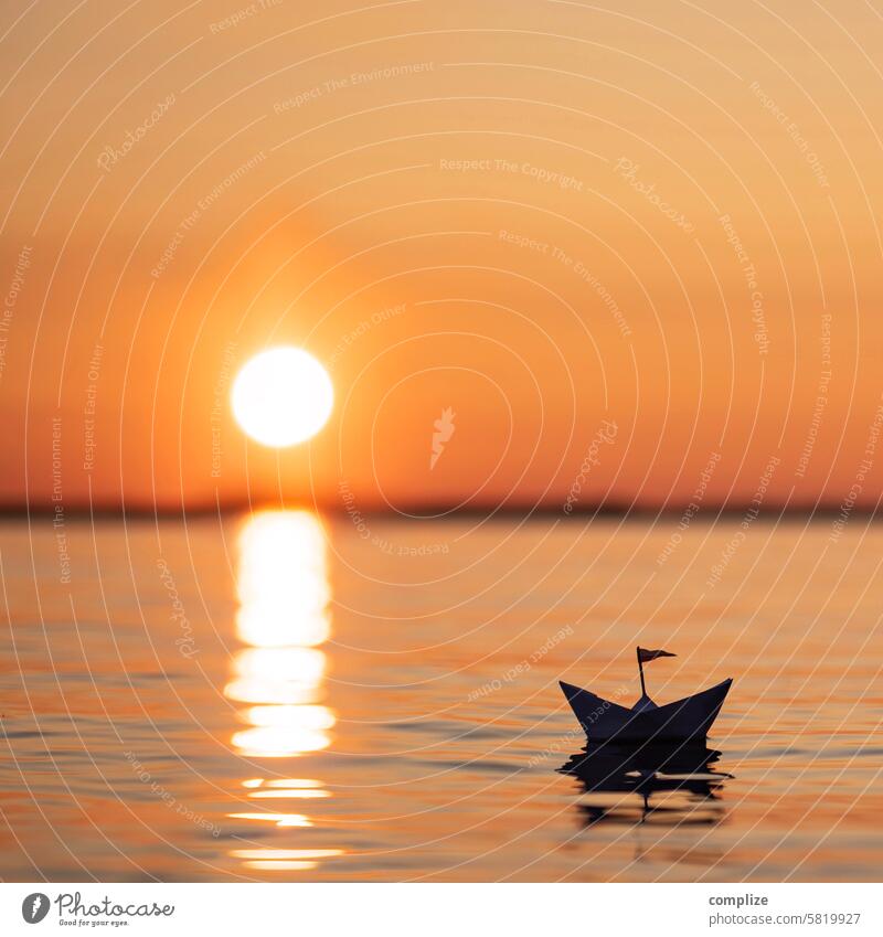 small paper ship sailing into the sunset on a lake in Finland Paper boat Sun Sunset Lake Ocean Water Wellness relax tranquillity Orange be afloat ship flag