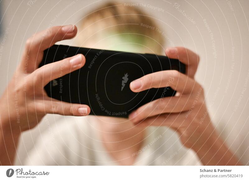 Child plays on a smartphone Screen Playing technology Cellphone entertainment Close-up hands Boy (child) focus Digital Mobile device Concentrate free time