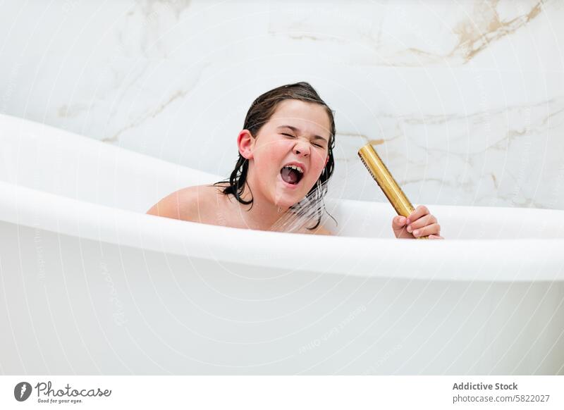 Young girl singing in bathtub, eyes closed with joy home bathroom playful kid music pretend performance child fun imagination water bath time hygiene leisure