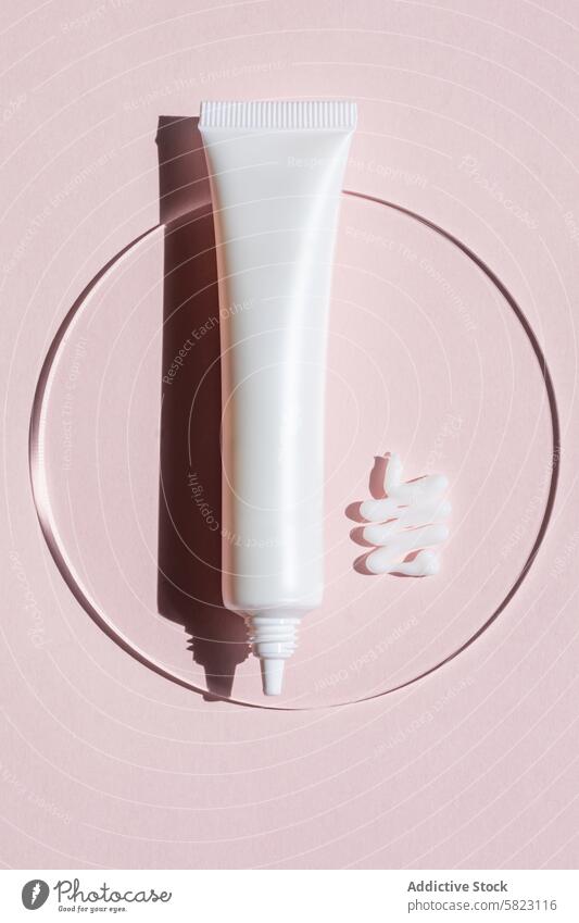 Cosmetic tube with cream smear on pink background cosmetic serum skin care beauty product dollop reflection mirror circular artistic packaging skincare lotion