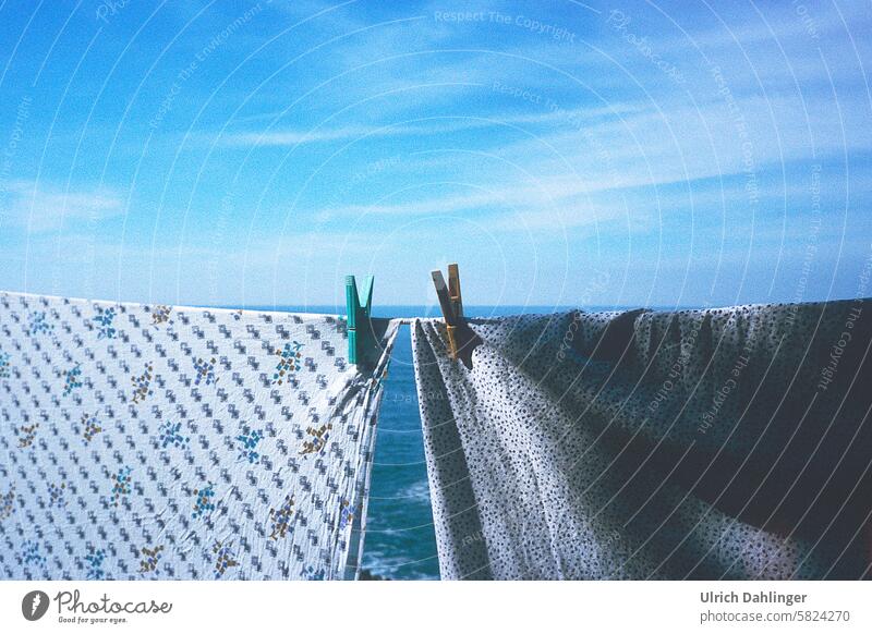 two pieces of laundry on a line with two clothespins in front of a blue sea and blue sky Ocean Sky Blue Folklore Romance Wash Laundry Longing Clothes peg