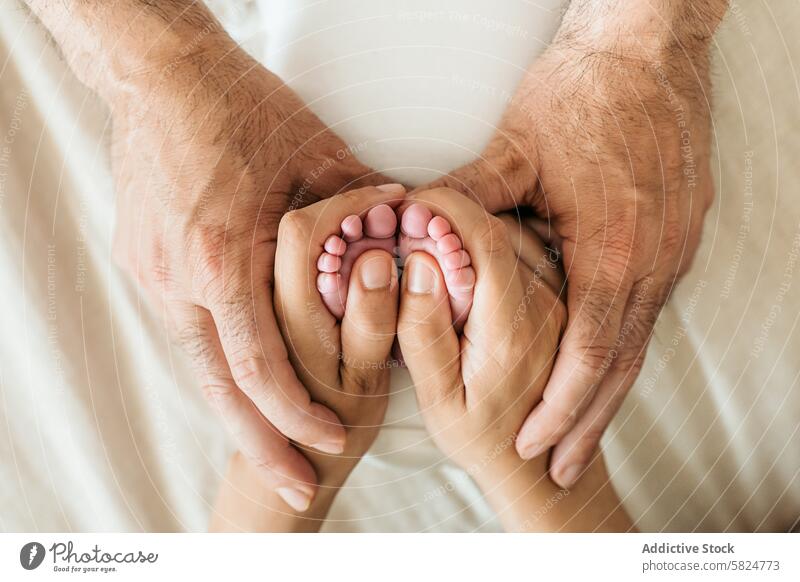 Newborn baby feet cradled by parents' hands newborn care love family bond tenderness protection parenthood nurture touch fingers toes support life infant