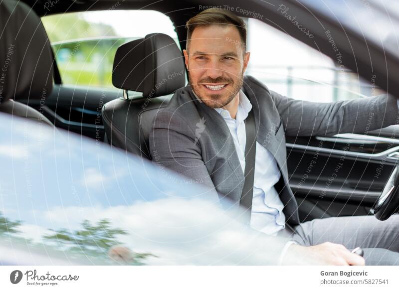 Smiling man enjoying a sunny drive in a modern car interior driving smiling steering wheel road trip enjoyment day transportation driver vehicle journey