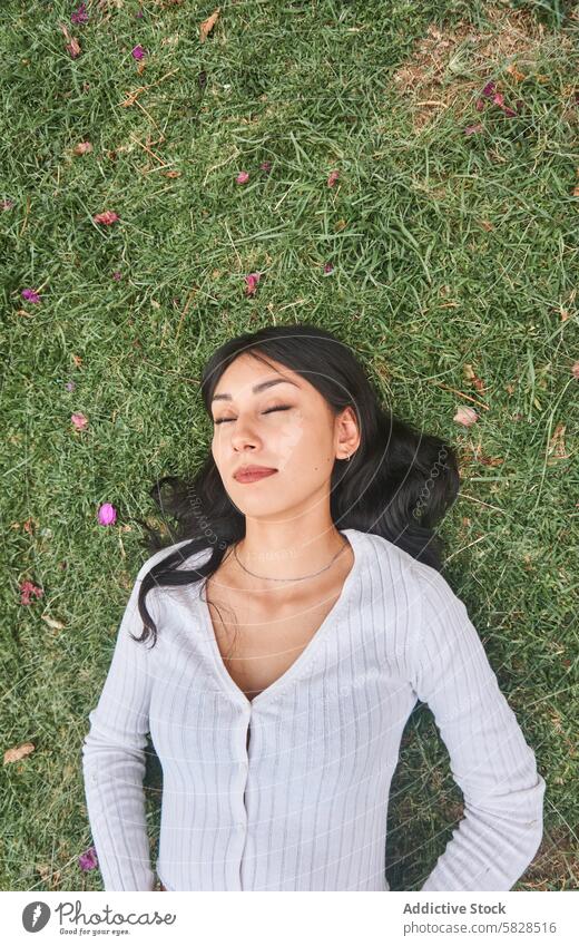 Serene Woman Enjoying a Relaxing Moment in Nature woman relaxing park nature serene tranquility grass eyes closed leisure outdoor relaxation greenery female