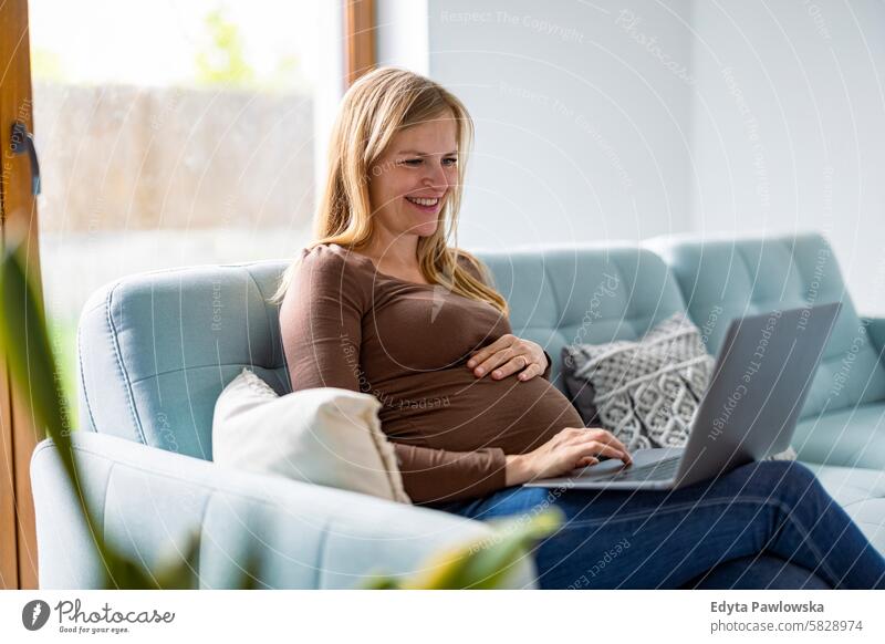 Pregnant woman working with laptop at home pregnancy pregnant adult anticipation awaiting baby belly birth body care caucasian child expectant expecting