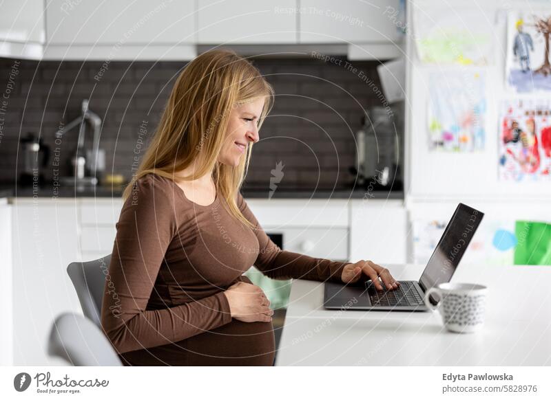 Pregnant woman working with laptop at home pregnancy pregnant adult anticipation awaiting baby belly birth body care caucasian child expectant expecting