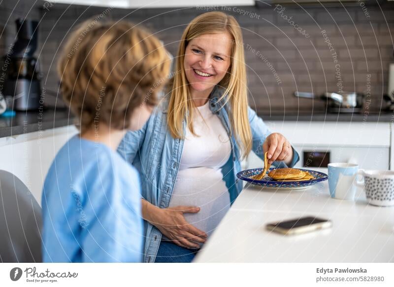 Little boy with his pregnant mother at home pregnancy adult anticipation awaiting baby belly birth body care caucasian child expectant expecting expectation