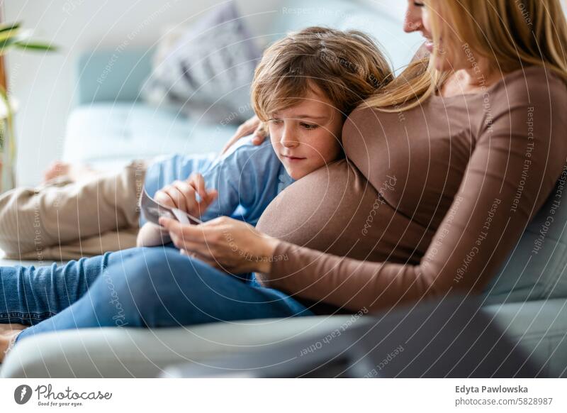 Little boy with his pregnant mother at home pregnancy adult anticipation awaiting baby belly birth body care caucasian child expectant expecting expectation