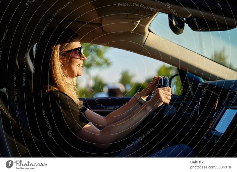 Happy woman is sitting in car. View through windshield driver enjoy happy female driving vehicle attentive travel adult attractive beautiful caucasian owner