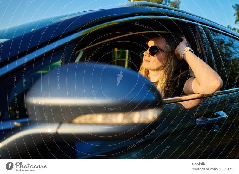 Woman wearing sunglasses is driving car woman driver sunny steering wheel vehicle smile daylight road trip rural sunlight portrait windshield outdoor looking