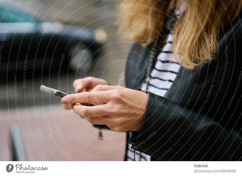 Woman using smartphone at city street woman communication online outdoors browsing hand holding device social media walking business message background