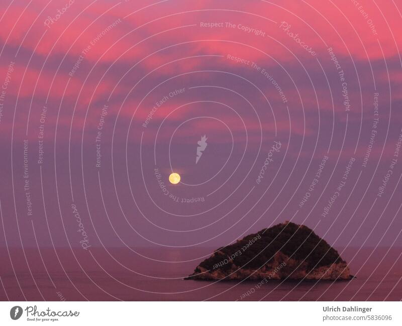 Full moon rising over the sea with a rocky island in the foreground. pink-violet picture mood Full  moon Twilight Evening Night Romance tranquillity Enz tension