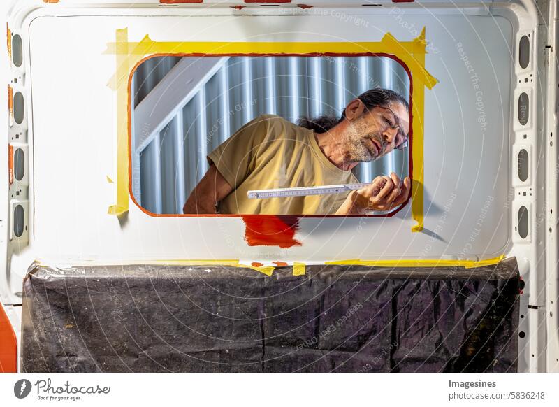 DIY - Camper conversion. Everything made to measure. Measuring windows. Man installs a side window. In the camper - male worker measures a side window Window