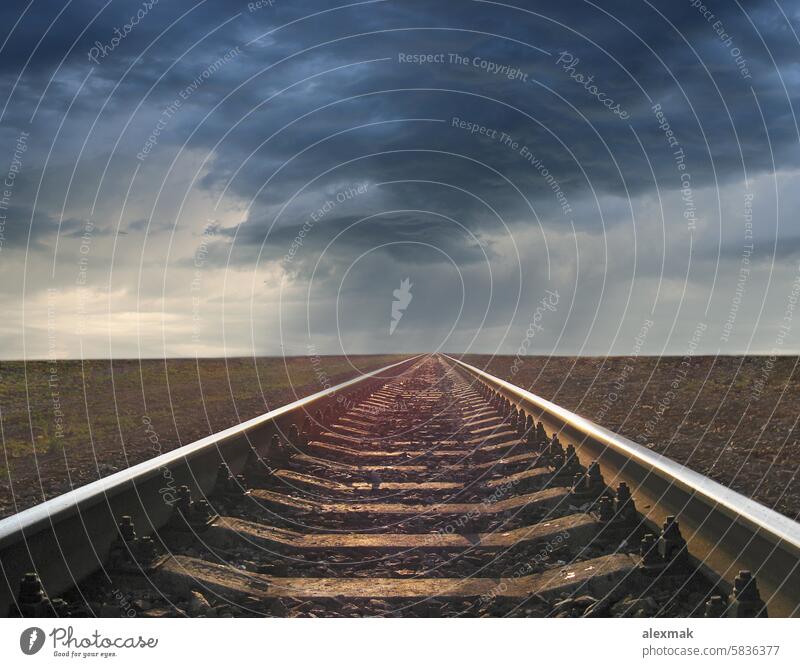 cloudscape with rails going away to the thunder clouds journey landscape railroad railway rain transportation steel sky scene iron country direction concept