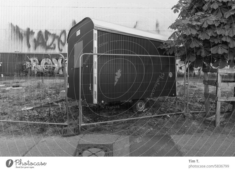 A seemingly forgotten construction trailer with a fence Prater Berlin Site trailer Fence Graffiti b/w Prenzlauer Berg chestnut avenue Capital city Downtown Town