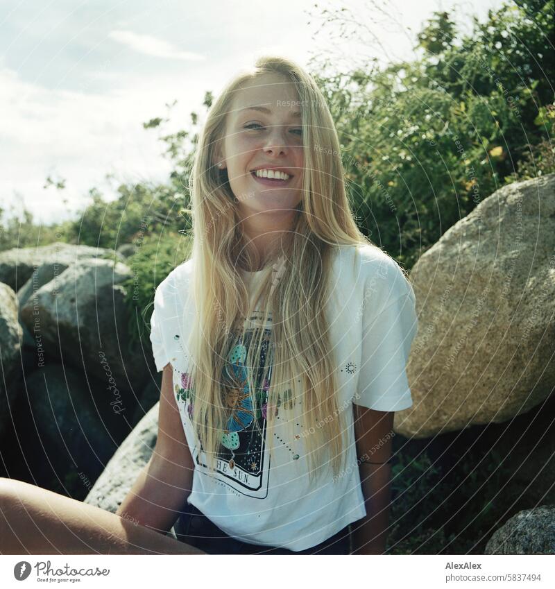 Young, blonde, tall woman on large stones on the beach and smiling - analog backlight shot Woman Girl Large 18 years Long-haired Blonde Summer Smiling Laughter