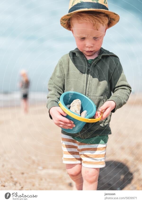 Little boy playing on the beach with a bucket of stones vacation Vacation mood Vacation & Travel Summer Beach Summer vacation Beach life Child untroubled