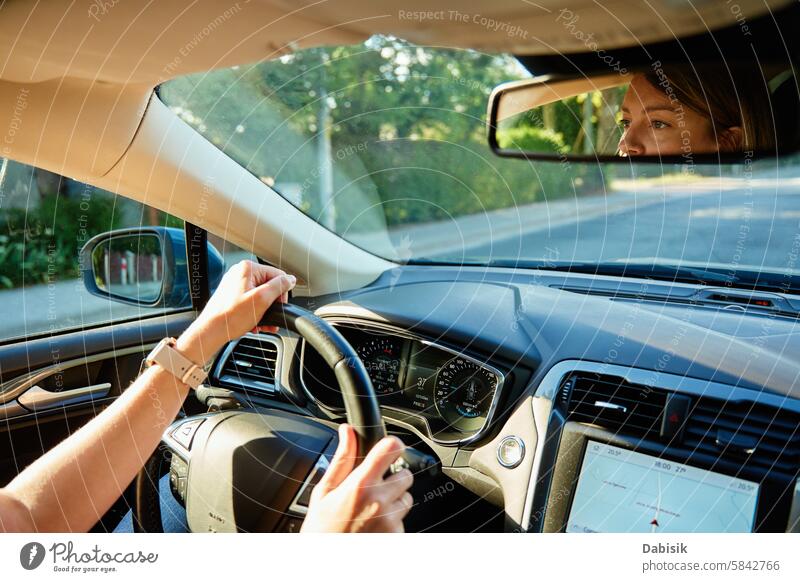 Woman driving car on country road. Back view of female driver in vehicle woman hand auto sunset mirror travel journey steering wheel dashboard back view