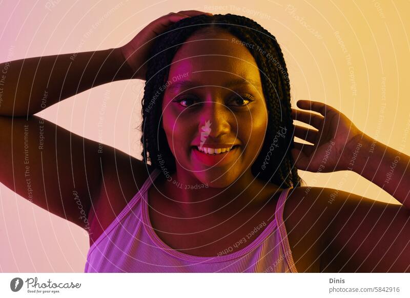Portrait of happy Black party girl dancing in neon lights dance Party portrait fun Black woman confidence braid hairstyle individuality curvy plus size beauty