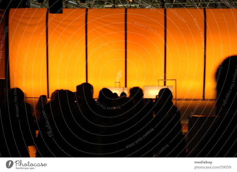 fair visitors Room Human being Large Yellow Commercial Assembly Date Orange Silhouette Crowd of people Anonymous Unrecognizable Unidentified Warm light