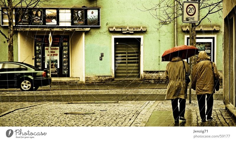 Cinema day. Umbrella Town Bad weather Human being Rain Street Cobblestones Sidewalk Jena