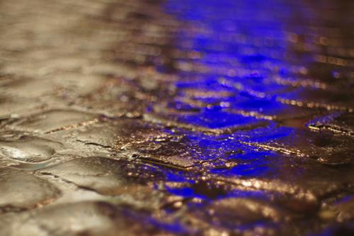 blue Traffic infrastructure Pedestrian Lanes & trails Blue Gray Black White Cobblestones Warning light Wet Water Rainwater Seam Smoothness Puddle Colour photo