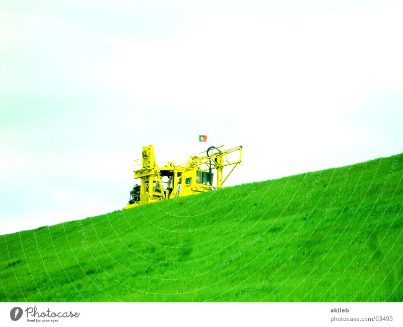 tilted position Excavator Yellow Green Clouds Lawn Sky Diagonal Copy Space top Copy Space bottom Hill Dam