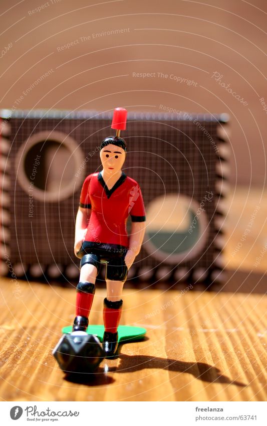The ball has corners 2.... Red Black Green Brown Wood White Shadow Statue Sports goal wall Table soccer Wood grain 1 Shallow depth of field Colour photo Goal