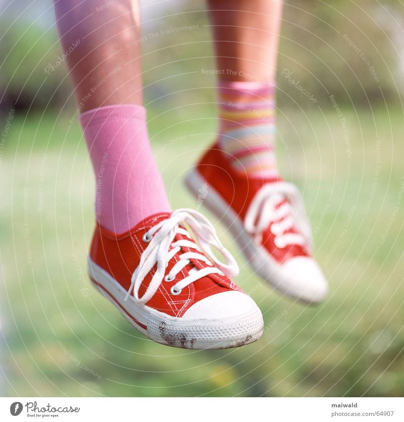 I sit here on my tree... Sneakers Footwear Red Stockings Striped socks Difference Shoelace Pink Calf Meadow Grass Exterior shot Depth of field Child Girl