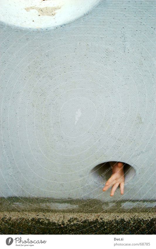 Child hand reaches through a hole in a concrete wall Joy Playing Hand Fingers 1 Human being Sand Playground Wall (barrier) Wall (building) Concrete Threat Small