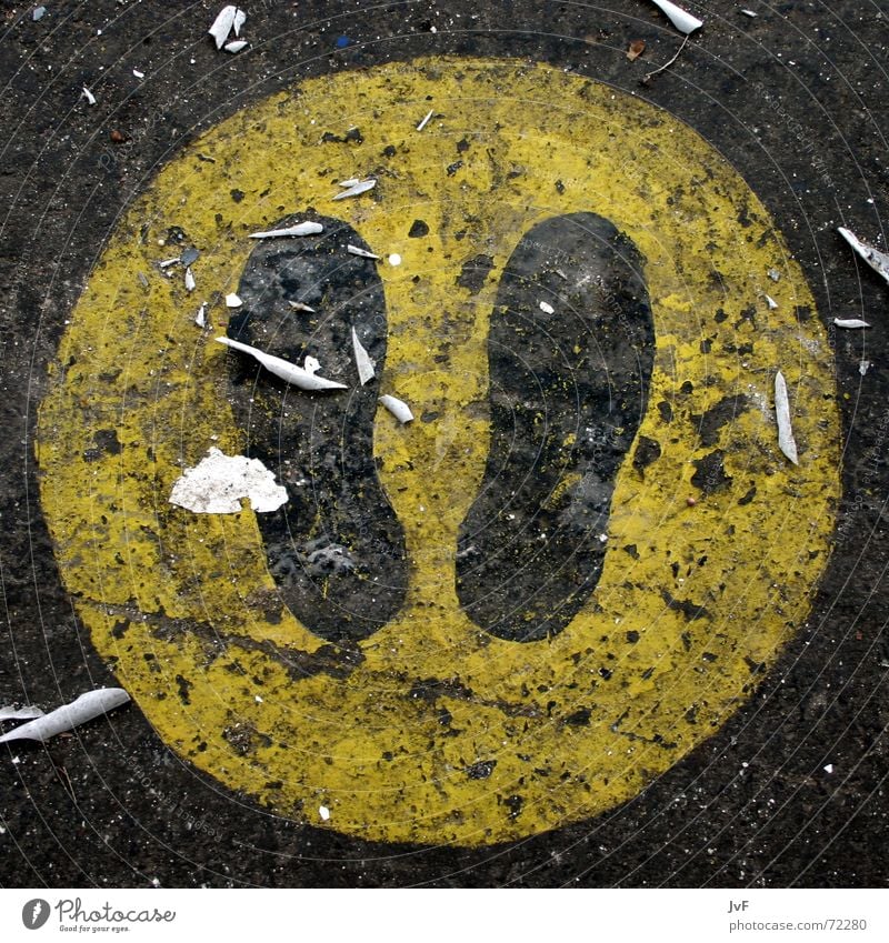 stay here Footprint Footwear Yellow Asphalt Tar Stand Going Stop Warning sign Black Sign Signs and labeling Floor covering Dirty
