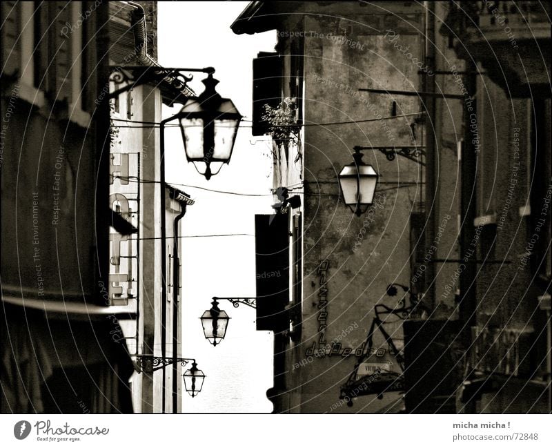A touch of the Middle Ages Alley Italy Lake Garda Lamp Facade Narrow Light Window Sun blind Medieval times Old yesterday striped Black & white photo