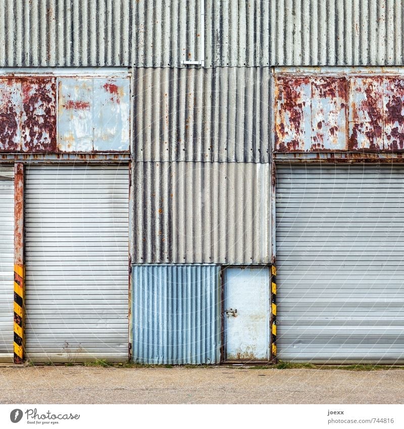 Portal closed Facade Door Gate Metal Old Hideous Retro Blue Brown Yellow Gray Black Transience Corrugated iron wall Line Rust Patina Colour photo Subdued colour