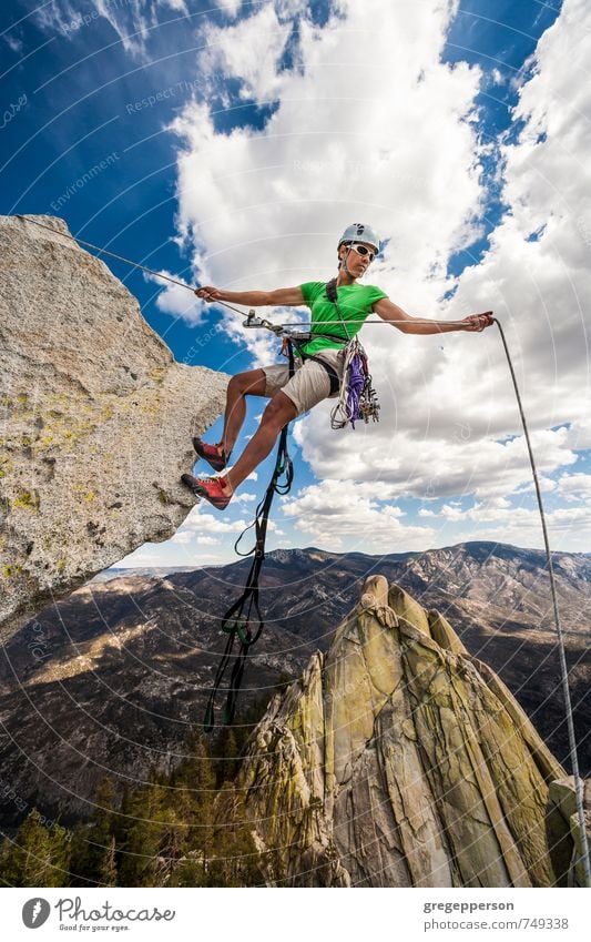 Climber rappels over the edge. Life Adventure Climbing Mountaineering Success 1 Human being 30 - 45 years Adults Clouds Helmet Self-confident Brave