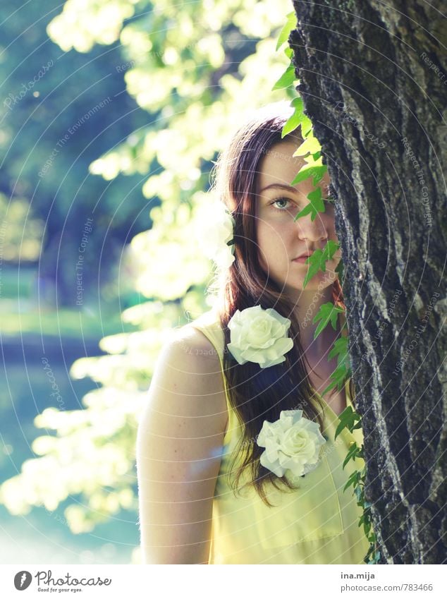 young woman with flowers in her hair hides behind a tree Human being Feminine Young woman Youth (Young adults) Woman Adults 1 18 - 30 years Environment Nature