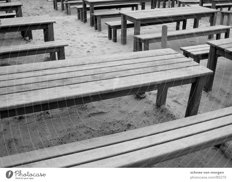 out on the beach Horizontal Wood Table Gray Black Beach Ocean Summer Winter Café Seating Places Arrangement Coast Gastronomy Black & white photo Line Bench Sand