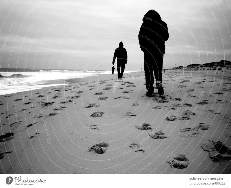 change of perspective Beach Ocean Lake Footprint Black White Gray 3 Man Waves Wind Gale Passion Hooded (clothing) Black & white photo Winter Water Tracks Feet