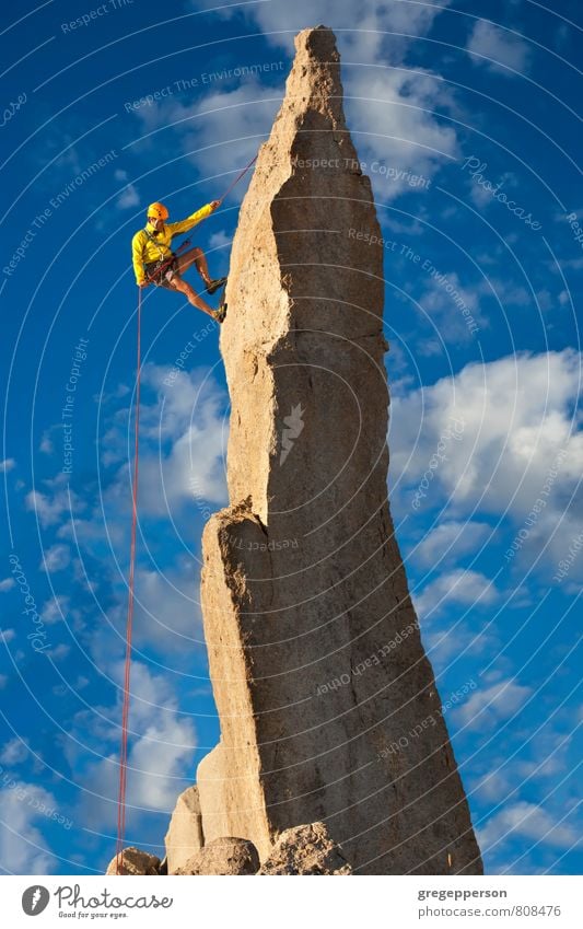 Climber tiptoes on the edge. Adventure Climbing Mountaineering Success Rope 1 Human being 30 - 45 years Adults Clouds Peak Helmet Self-confident Brave