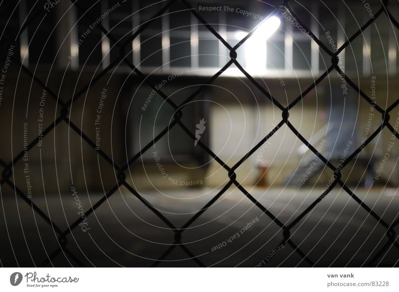 cross-linked Grating Fence Closed Light Lamp Exposure Asphalt Wire Wire netting Window Night Dark Cold Ashtray Loneliness Grief Wall (building) Wall (barrier)