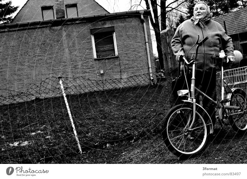 storm damage To talk Village road Chatty Folding bicycle Nostalgia for former East Germany Grandmother Farm Neighbor Fence Woman Senior citizen Wire netting