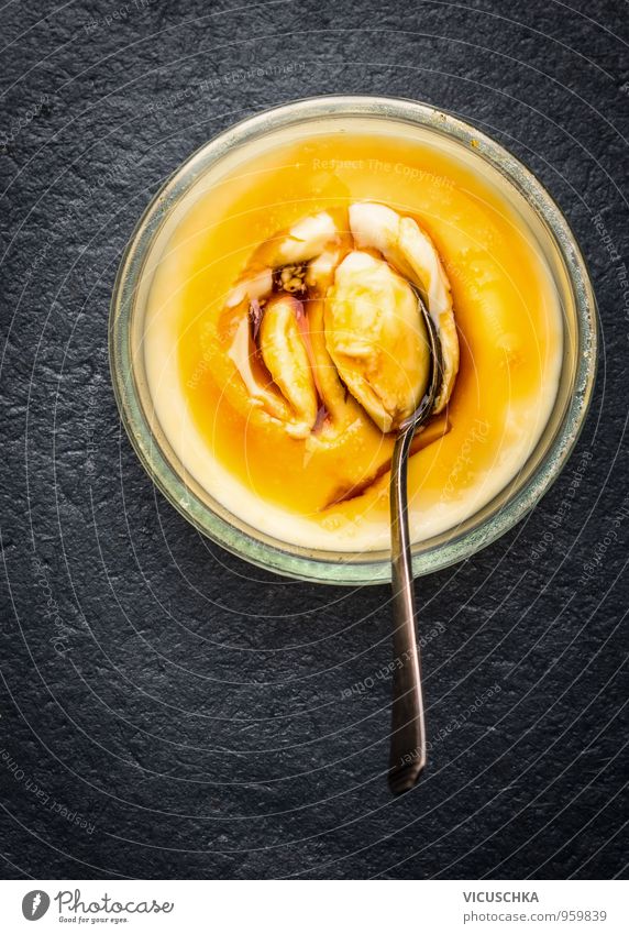 Cream Brulee in glass bowl and spoon Dessert Nutrition Banquet Bowl Spoon Restaurant Yellow Pudding brulee Panna Cotta caramel Gray Table Structures and shapes