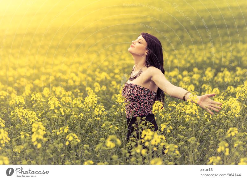 Beautiful young woman in summer happiness on yellow meadow from rape to horizon. Pretty girl with zest for life enjoys the sunshine break and life. Rest and recharge energy from time environment stress in nature idyll.
