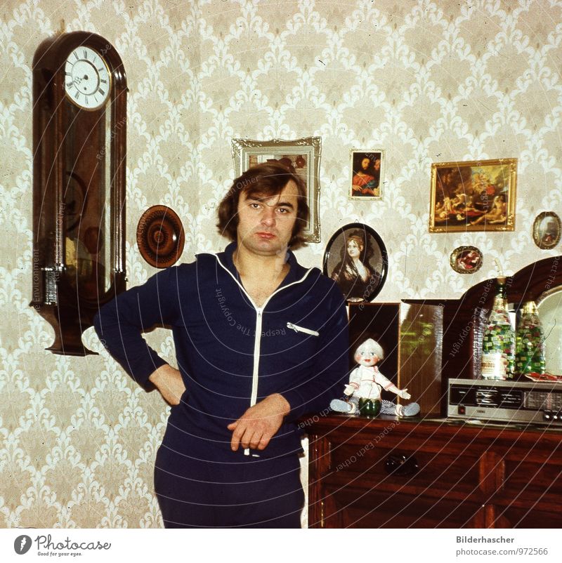 Young man stands at the cupboard in the old furnished apartment Man Looking Living or residing Relaxation Long-haired Old Wallpaper Image Decoration portrait
