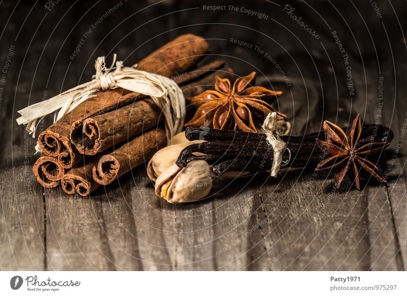 Cinnamon, anise, vanilla beans and nuts lie on rustic wooden table. Christmas spices Food Herbs and spices Vanilla pod Star aniseed Pistachio baking ingredients
