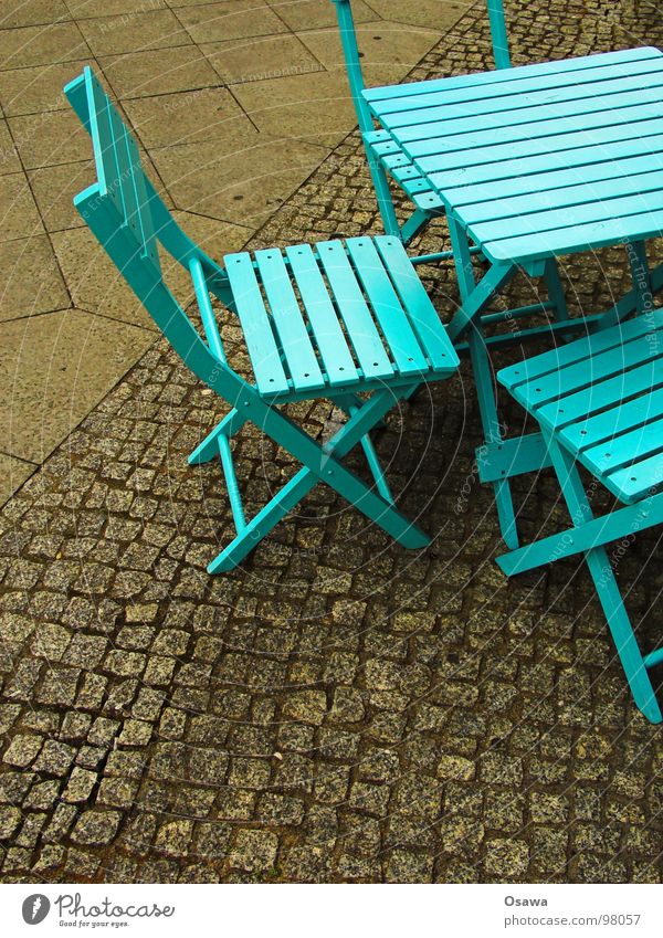 Street furniture in cyan Furniture Table Chair Wood Café Sidewalk café Cyan Green Greeny-blue Cobblestones Traffic infrastructure Camping chair Blue