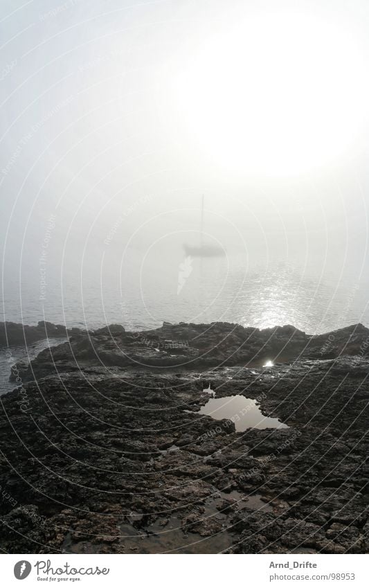 Ship in the fog Fog Ocean Watercraft Sailboat Coast Puddle Stone Morning fog Beach Sky Rock Rope
